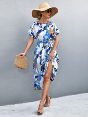 Blue abstract print midi dress with tie waist and short sleeves.