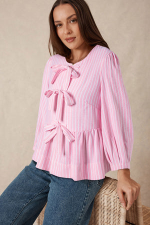 Blush pink striped peplum blouse with bow embellishments and puff sleeves.