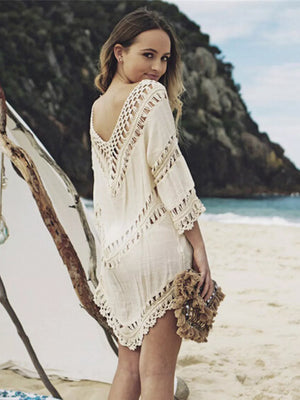 White crochet V-neck cover-up with fringe trim and cutout details.