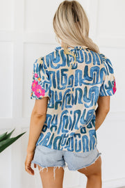 Abstract print puff sleeve top with floral detail on sleeve.