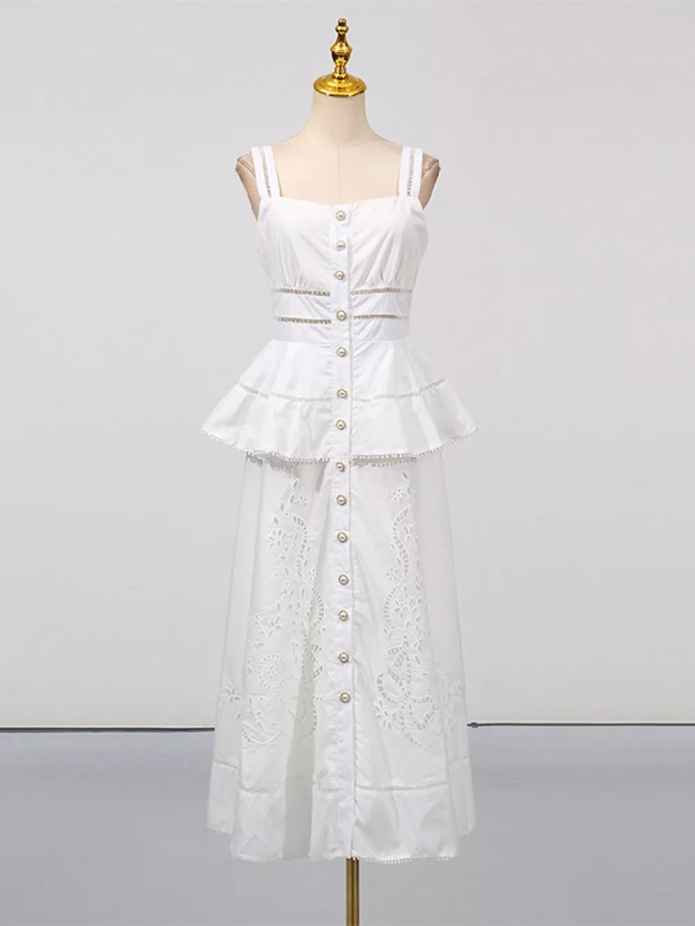 White eyelet embroidered midi dress with button front, tiered peplum and cutout details.