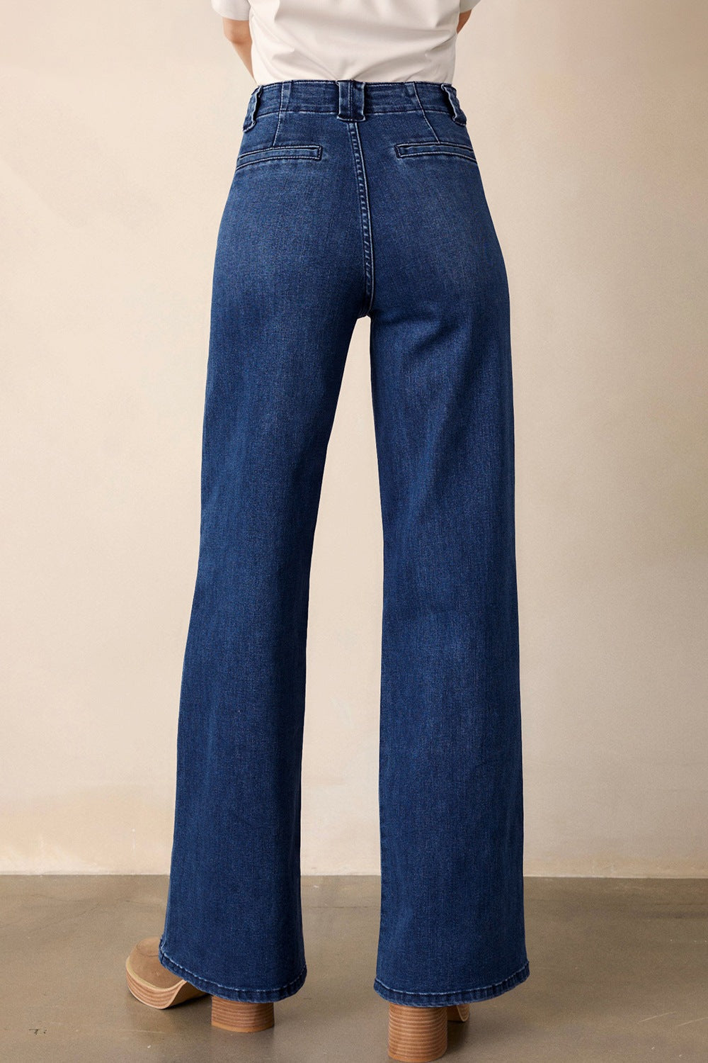 Mid-rise straight leg jeans in dark wash denim with button closure and a wide leg.