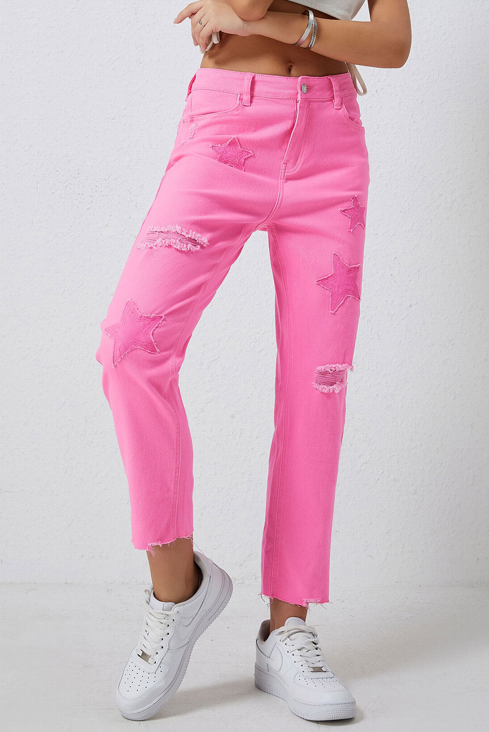 Pink denim jeans with star patches and distressed details