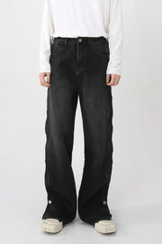 Dark baggy denim jeans with snap hem detail and side slits.