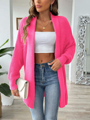 Ribbed knit cocoon cardigan in bright pink with open front and long sleeves.