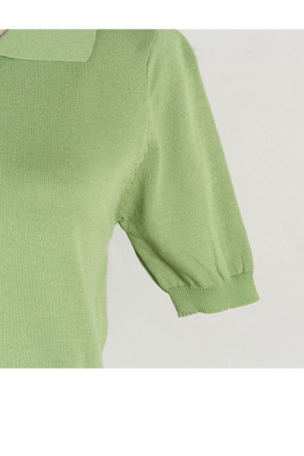Light green button-down knit polo top with short sleeves and a ribbed hem.