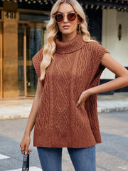 Cable knit turtleneck vest in caramel acrylic with side slits, styled with jeans.