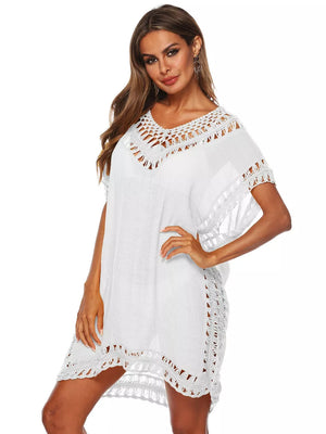 White crochet v-neck cover-up dress with intricate cutout details and short sleeves.