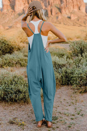 French blue cotton wide-leg jumpsuit with pockets and adjustable straps, styled with a white tank top.