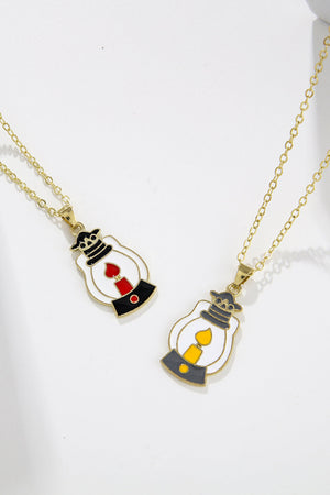 Spooky Season enamel pendant necklaces with lantern charms, one with red flame, one with yellow flame.