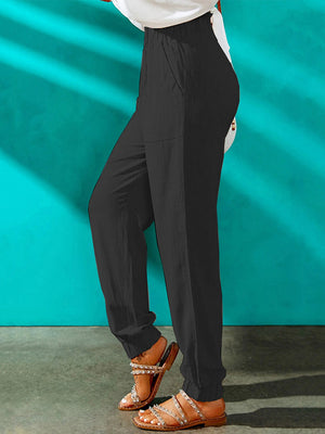Black paperbag waist cuffed hem trousers with pockets, shown on a model.