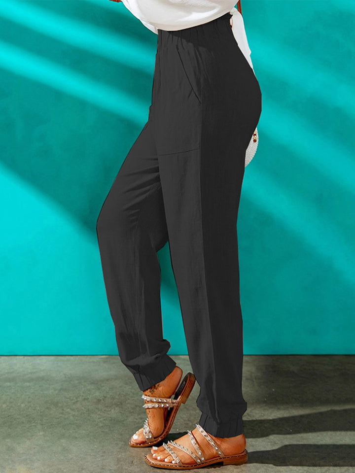 Black paperbag waist cuffed hem trousers with pockets, shown on a model.