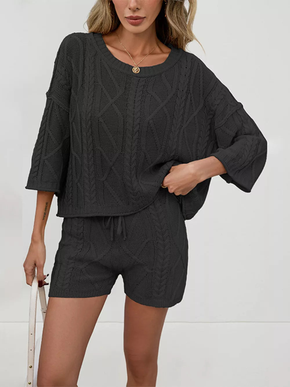 Black cable-knit two-piece sweater set with crew neck sweater and drawstring shorts.