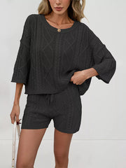 Black cable-knit two-piece sweater set with crew neck sweater and drawstring shorts.