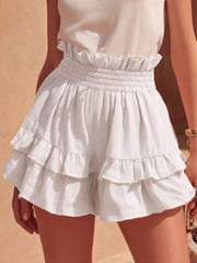 White ruffled high-waisted shorts with smocked waistband and tiered hem.