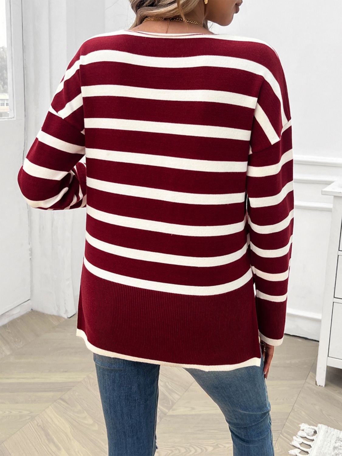 Burgundy and white striped oversized V-neck knit sweater with long sleeves.