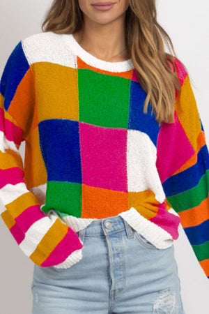 Patchwork knit crewneck pullover sweater with colorful blocks and stripes.
