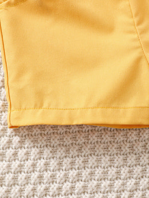 Yellow baby set detail with tropical print and bow tie accent