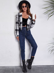Chic plaid jacket in white and black with button details, styled casually with jeans.