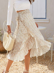 Asymmetric wrap skirt with leaf print and ruffles, tied at the waist.