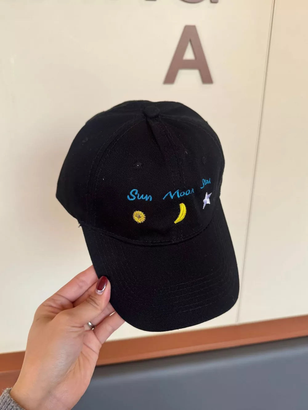 Black cotton baseball cap with celestial embroidery and text detail