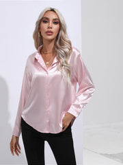 Blush pink satin button-front blouse with long sleeves and a collared neckline.
