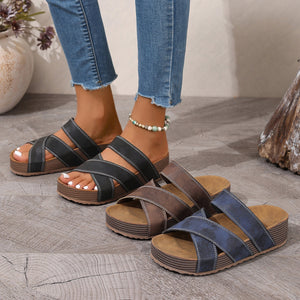 Criss-cross open-toe platform sandals in black, brown, and blue with chunky soles.