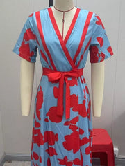 Vibrant floral maxi dress in light blue with red floral print, V-neck, short sleeves, and tie waist.