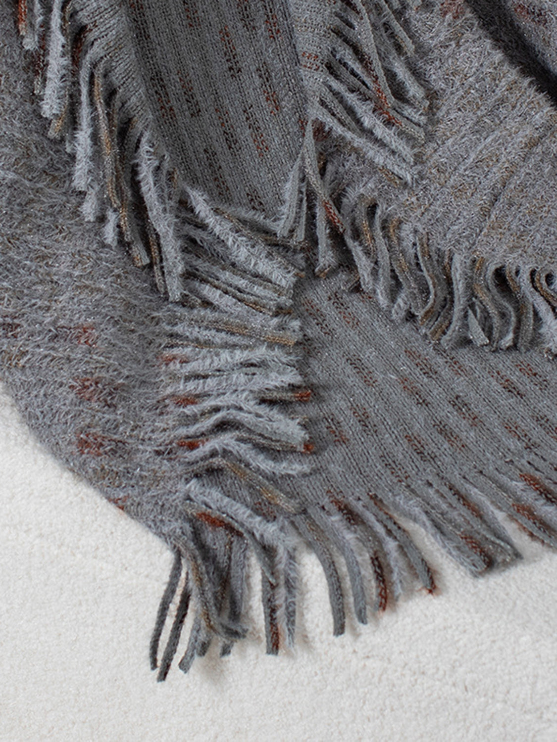 Textured fringe shawl cardigan in dark gray acrylic with subtle copper threads and fuzzy trim.