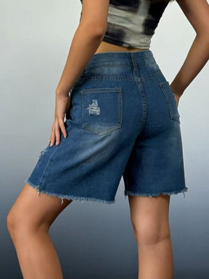 Distressed denim shorts in dark blue with frayed hem and ripped details.