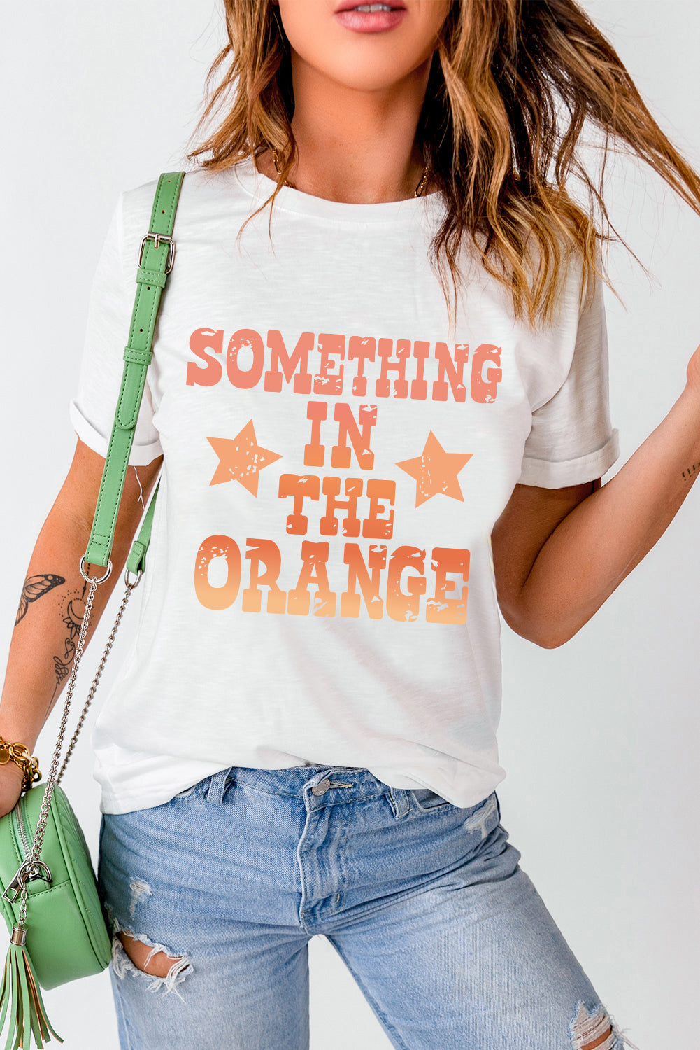 White t-shirt with faded retro graphic print and orange stars.
