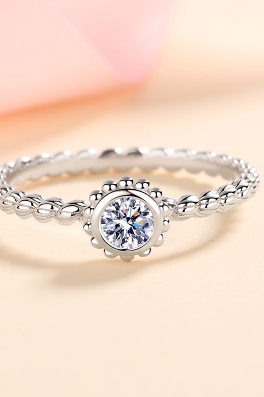 Silver beaded band ring with a moissanite solitaire center stone.