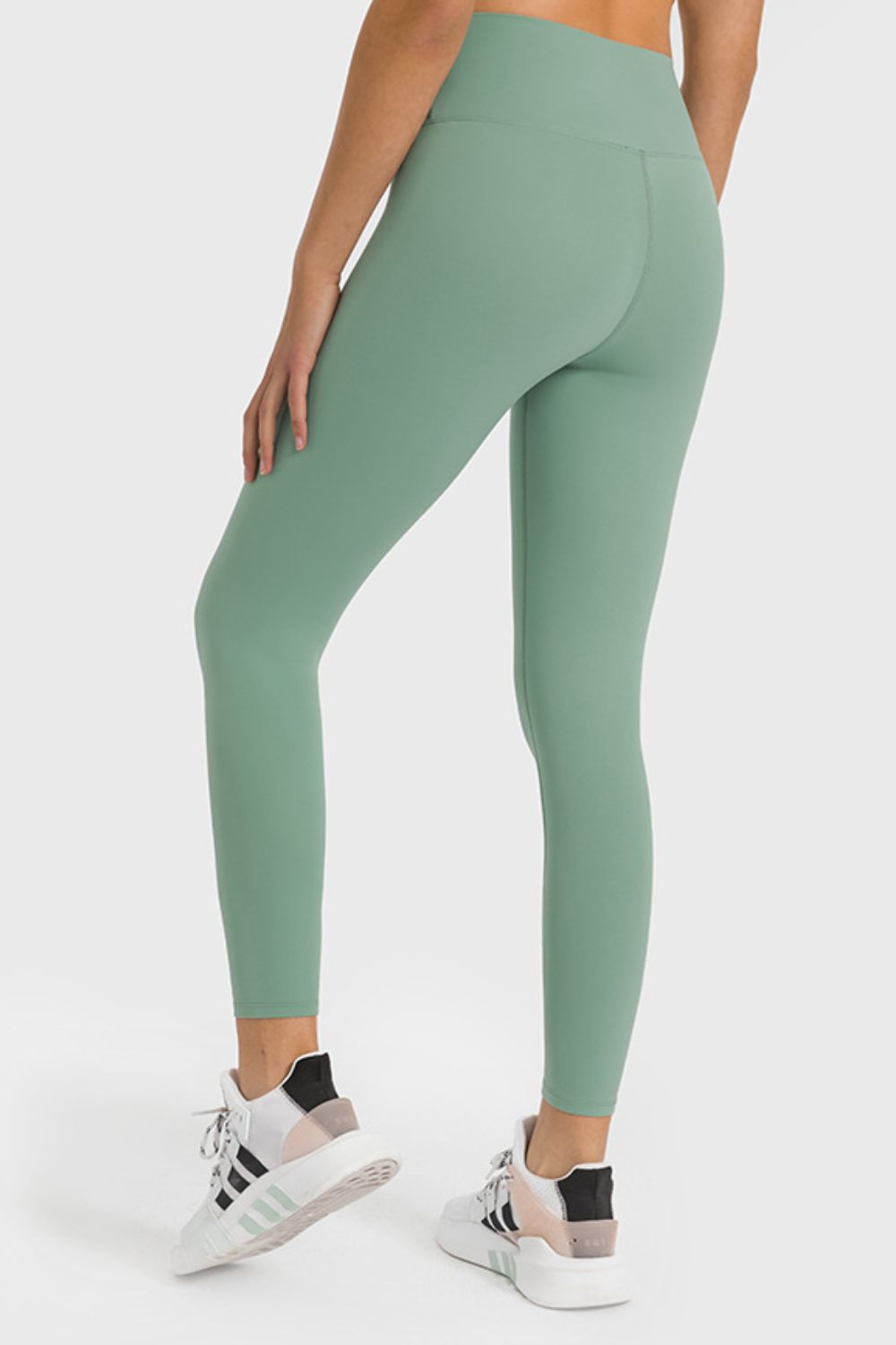 Green high-waist performance leggings with ankle length and seamless detail.