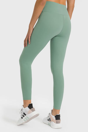 Green high-waist performance leggings with ankle length and seamless detail.