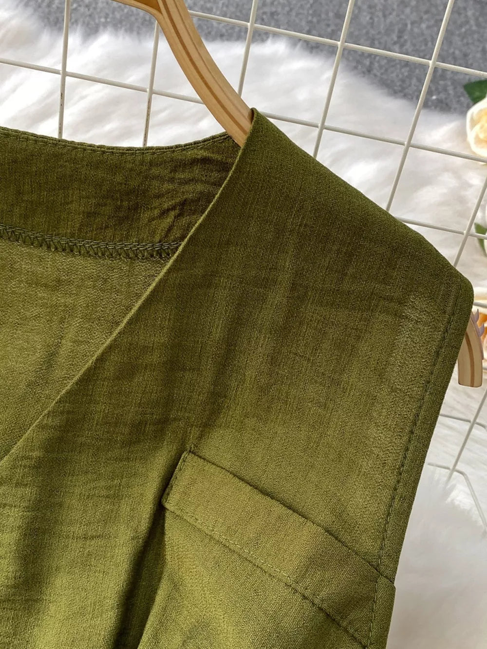Green V-neck wide leg jumpsuit detail showing pocket and stitching