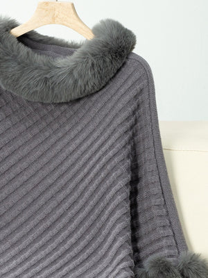 Dark gray knit poncho with faux fur trim at the collar and cuffs.