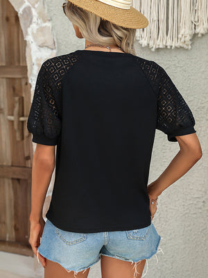 Black waffle knit top with sheer lace raglan sleeves and puff cuffs.