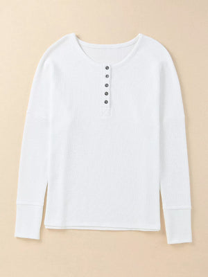 White textured cotton henley shirt with button placket and long sleeves.