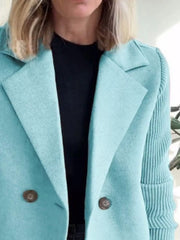 Pastel blue double-breasted coat with knit sleeves and button detail.