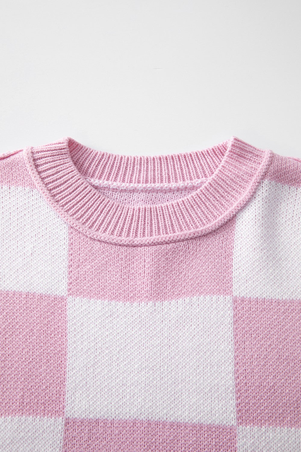 Checkerboard knit crewneck sweater in Dusty Pink and white acrylic with ribbed neckline.