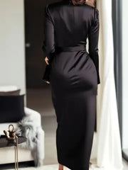 Black satin maternity dress with tie waist and long sleeves.
