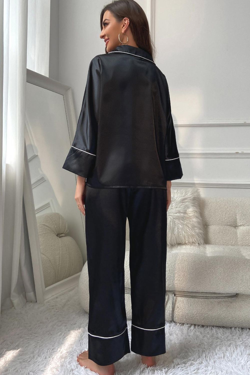 Black satin pajama set with contrast trim, relaxed fit pants and long sleeve top.