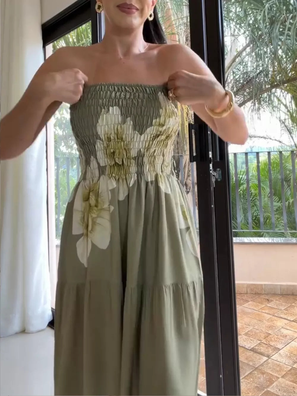 Green floral tiered maxi dress with smocked bodice and strapless neckline.