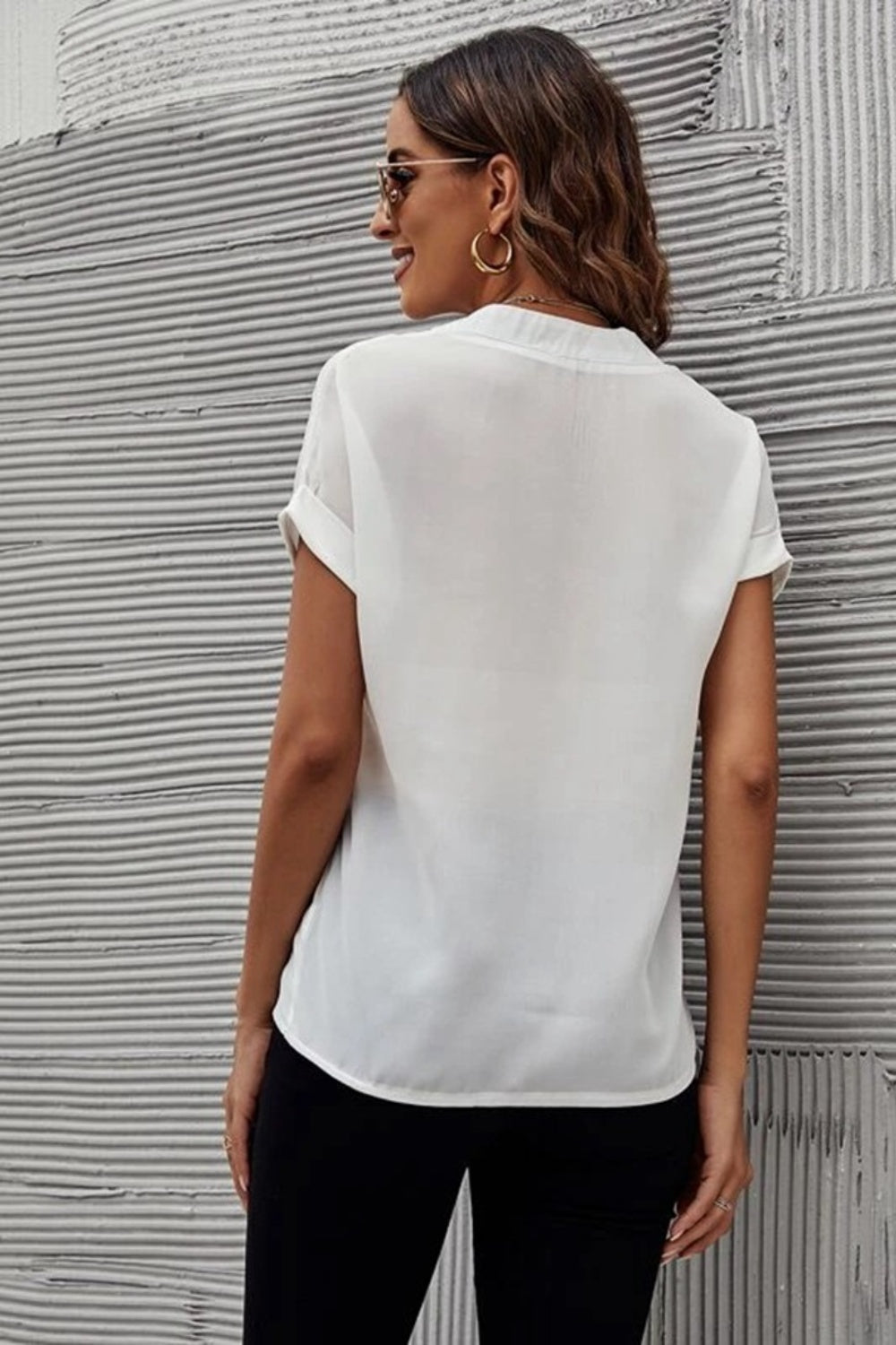 White plunge front blouse with cuffed short sleeves and a relaxed fit.
