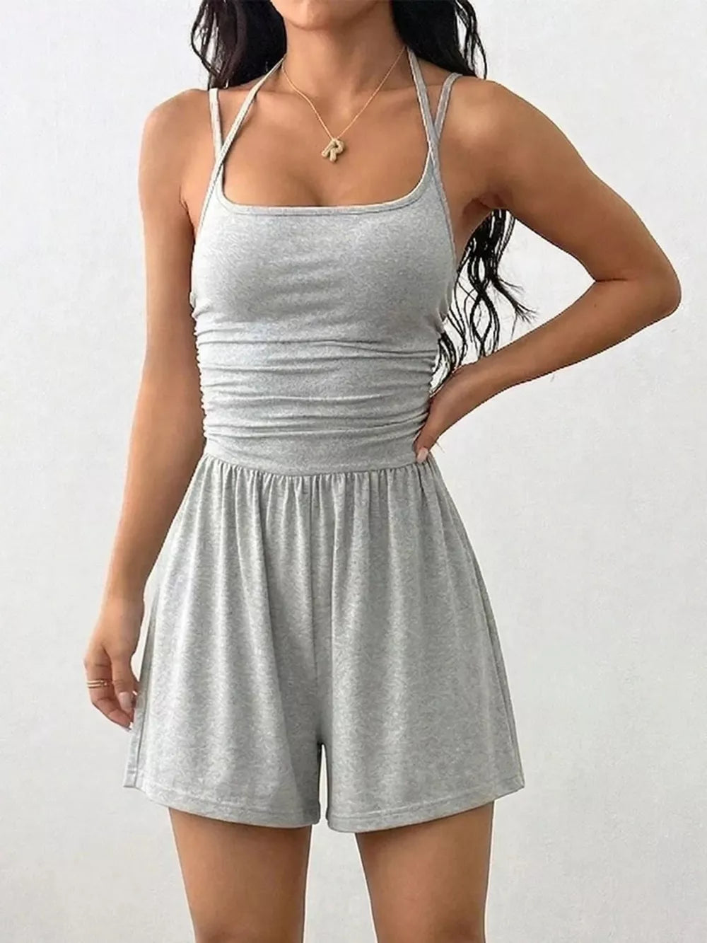 Light gray ruched spaghetti strap romper with square neckline and wide leg shorts.
