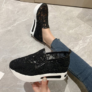 Black lace mesh slip-on flats with white soles and a casual style.