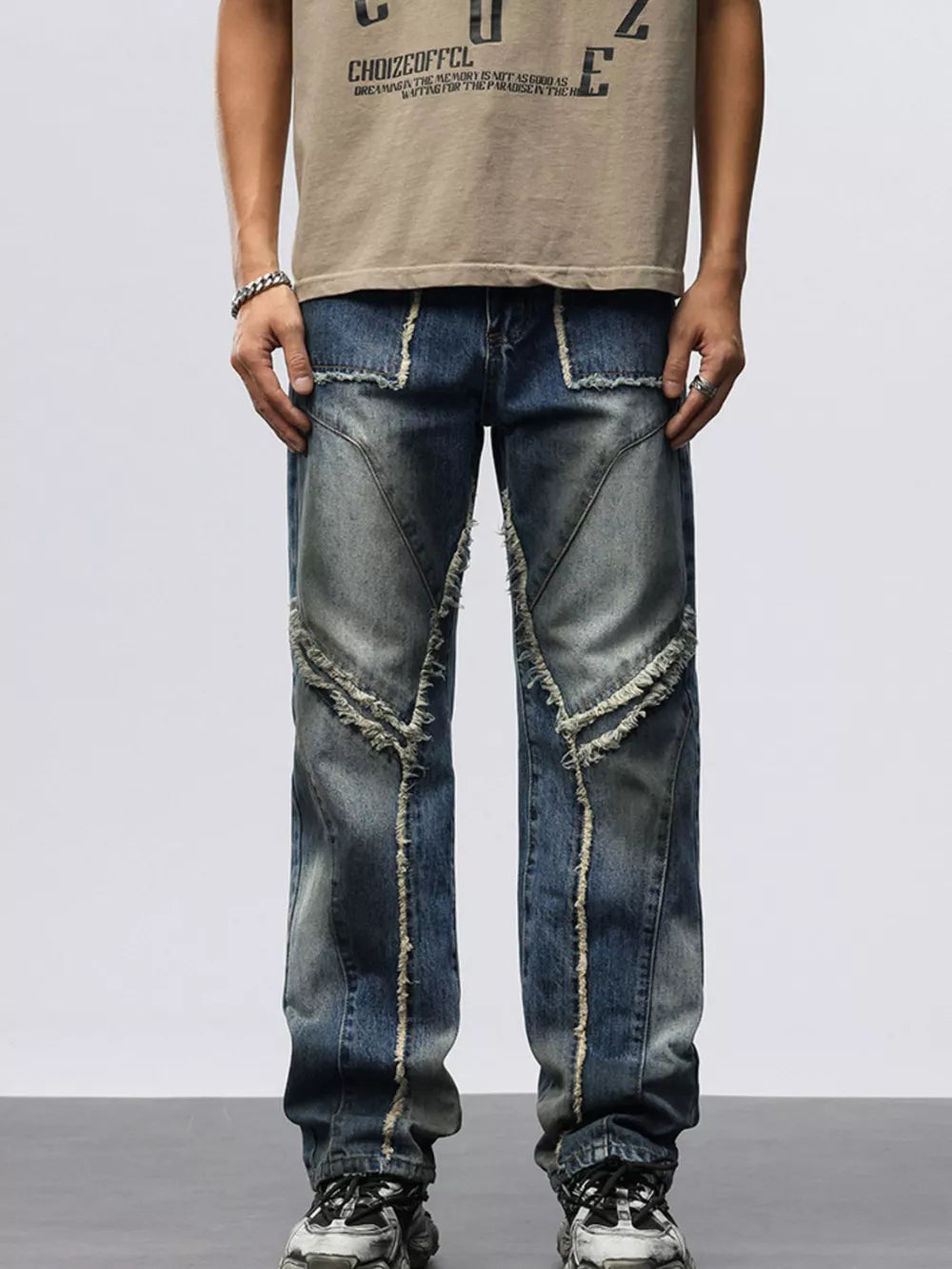 Men's blue denim wide leg jeans with frayed hem detailing and patchwork design.