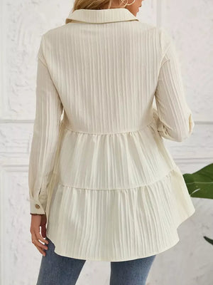 Cream textured tiered button-down shirt with crinkled fabric and button cuffs.