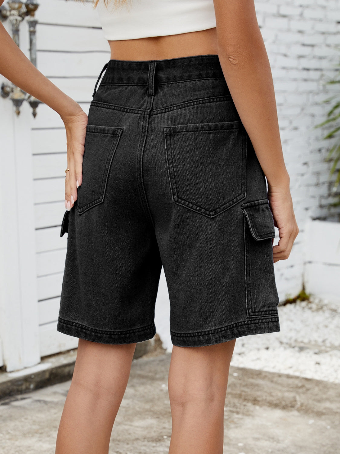 Black denim Bermuda cargo shorts with multiple pockets and a relaxed fit.
