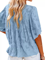 Blue textured V-neck button-down blouse with ruffled detail and short sleeves.